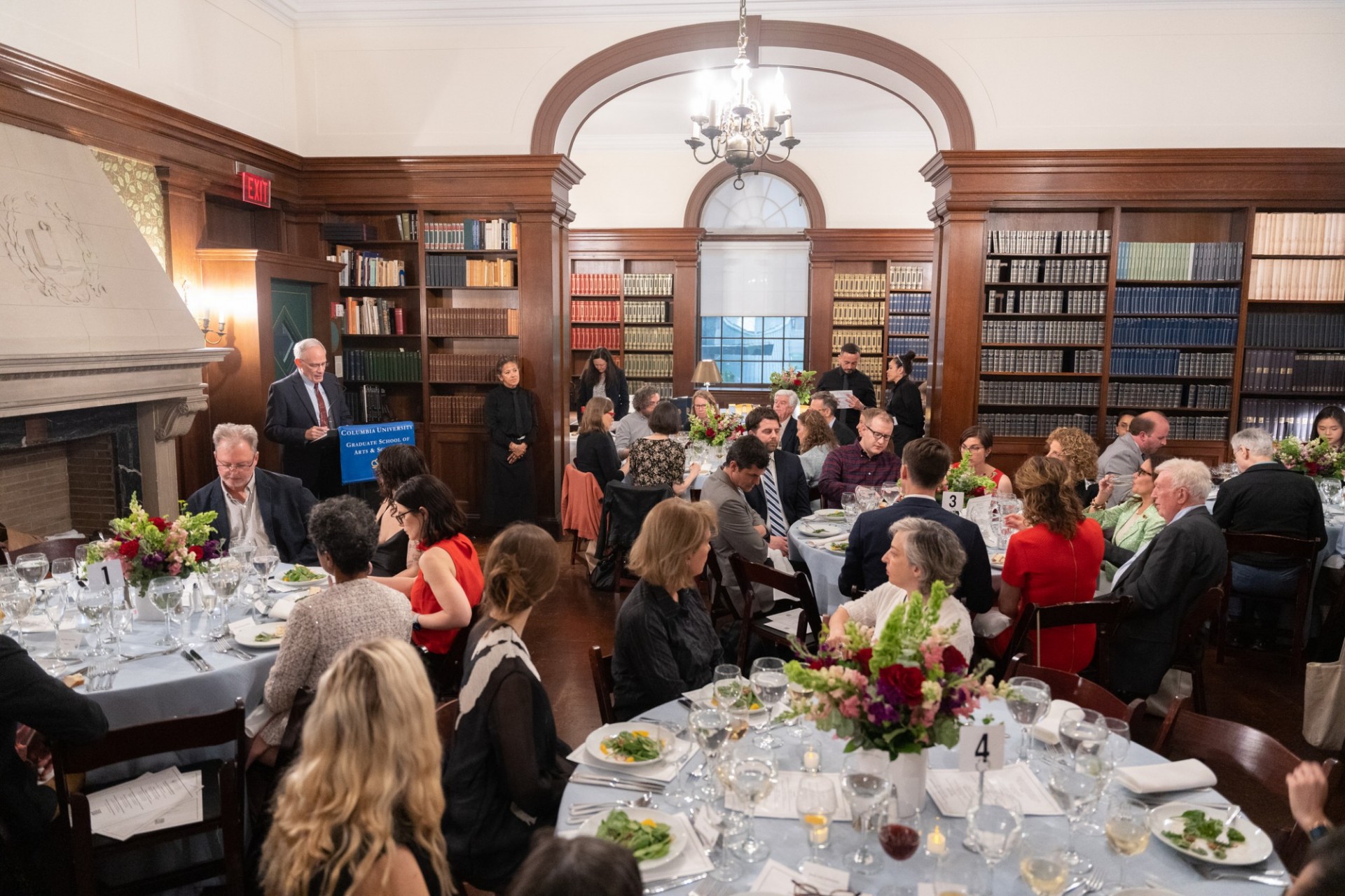 Room full of people at tables, celebrating