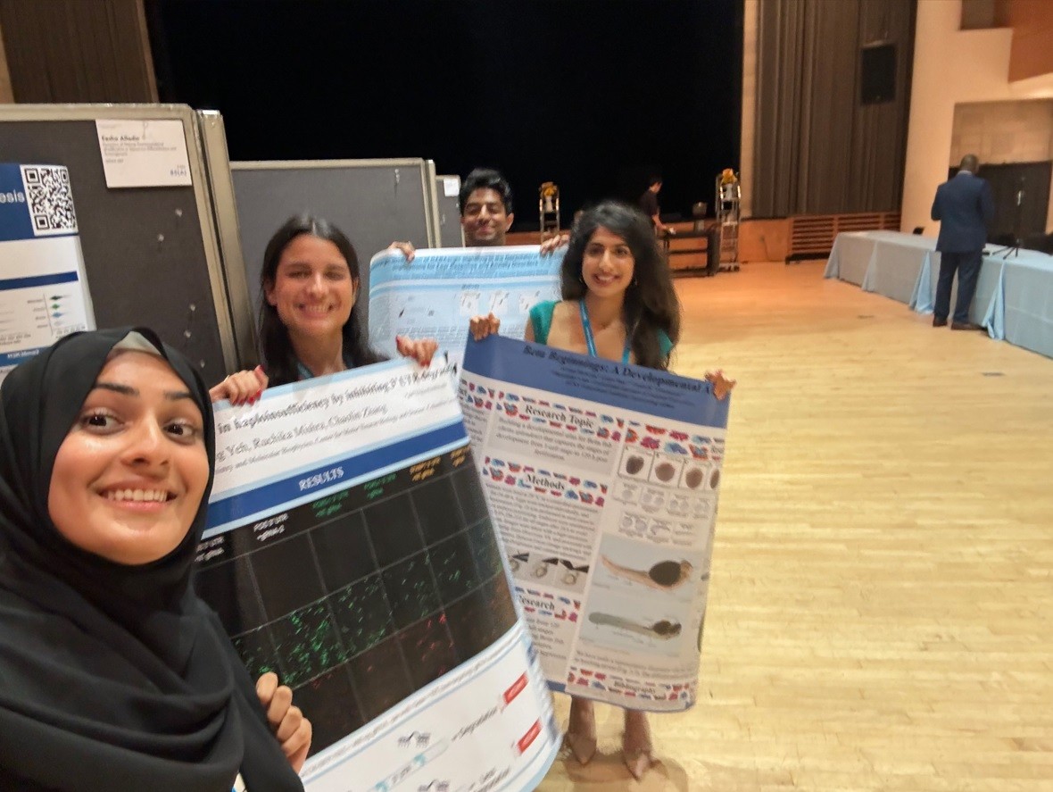(L to R) Eesha Alladin, Amanda Lopez, Sid Varman, and Arwaa Mehran support each other at a symposium during the Summer Research Program. 3 students at a symposium, holding up posters with research information