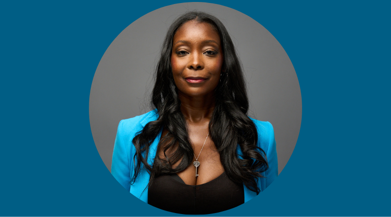 A portrait of a woman in a blue blazer and black shirt with long black hair.