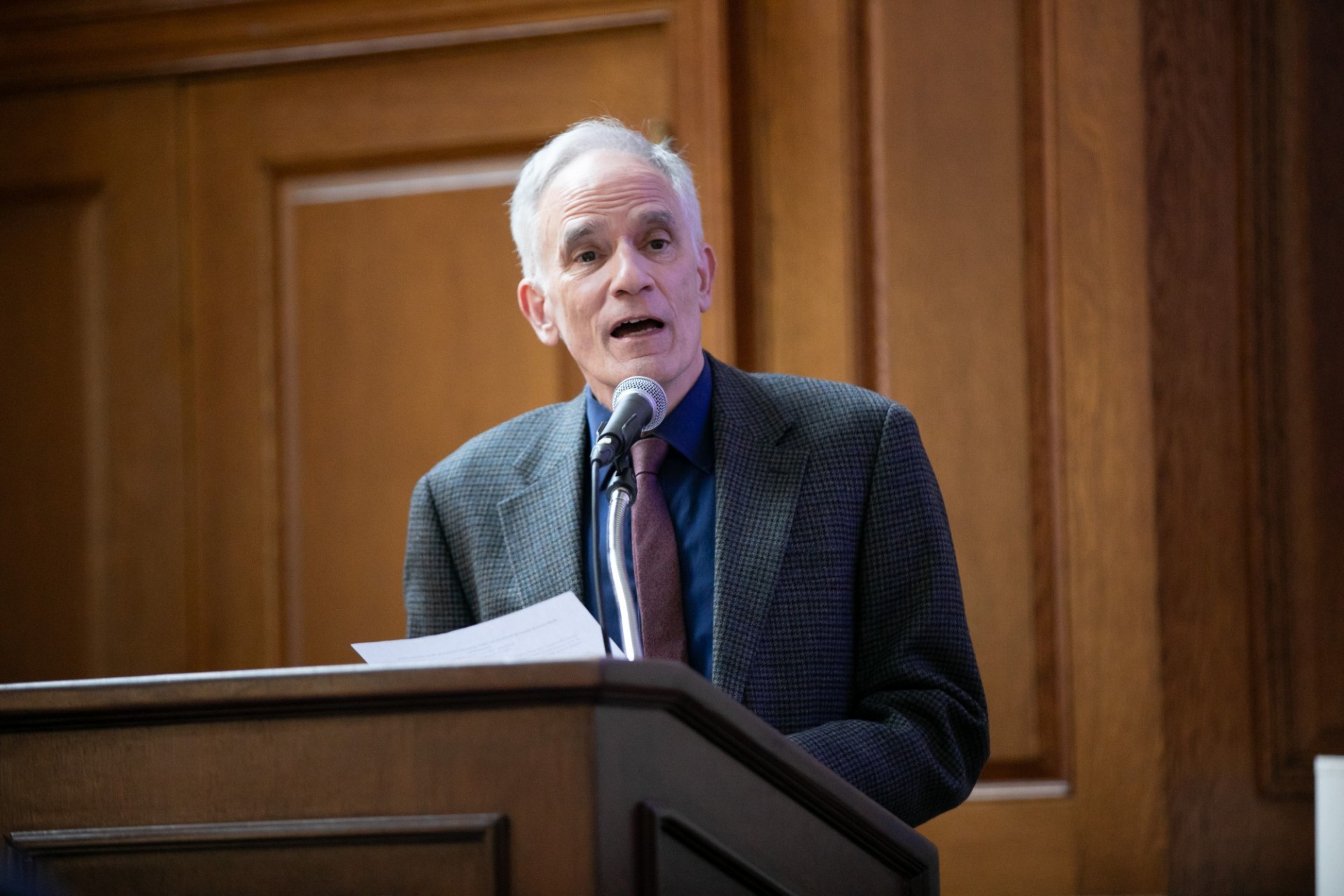Dean Carlos Alonso gives opening remarks Dean of GSAS, man in suit at lectern, speaking