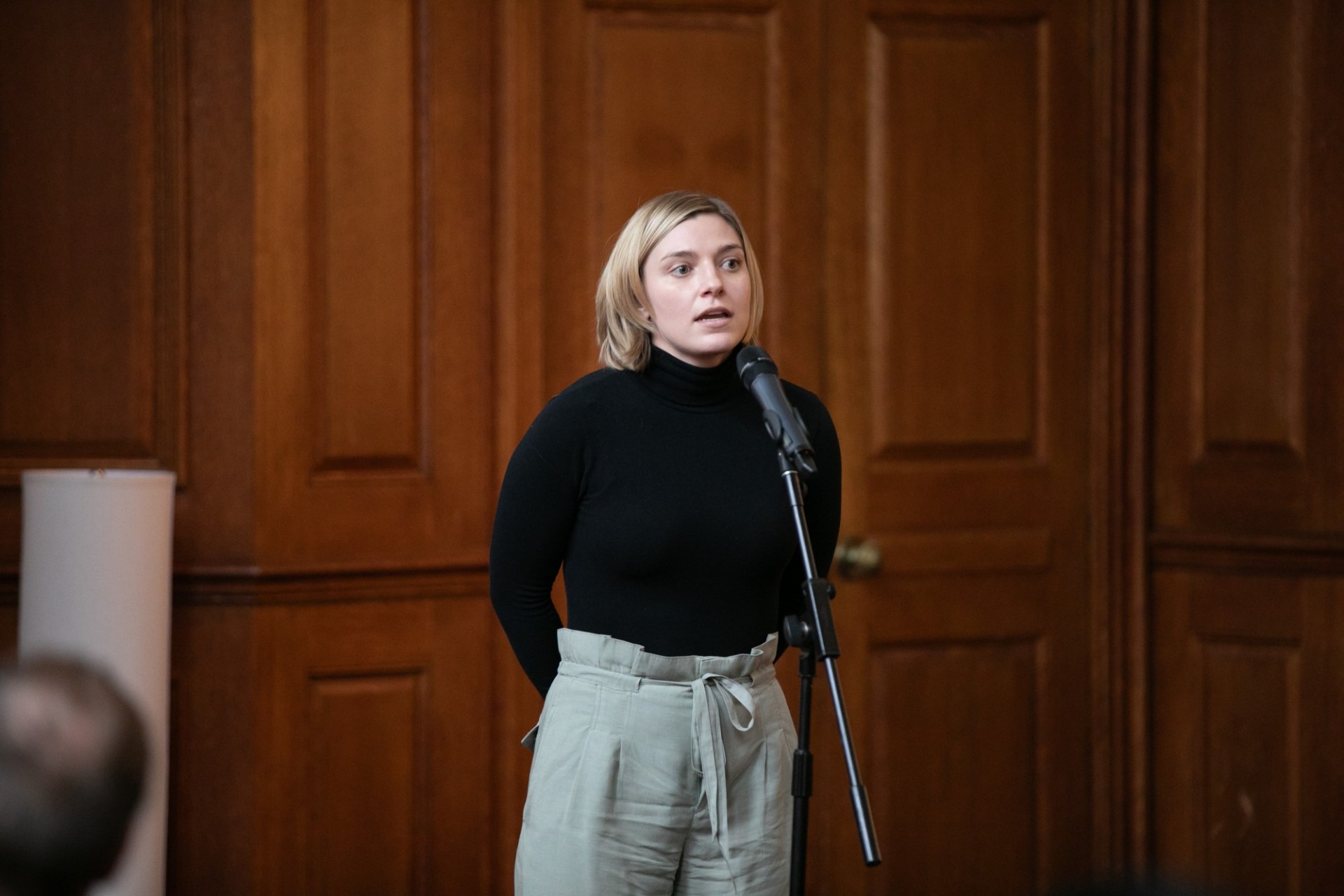 Female student standing and giving a speech in front of a slide