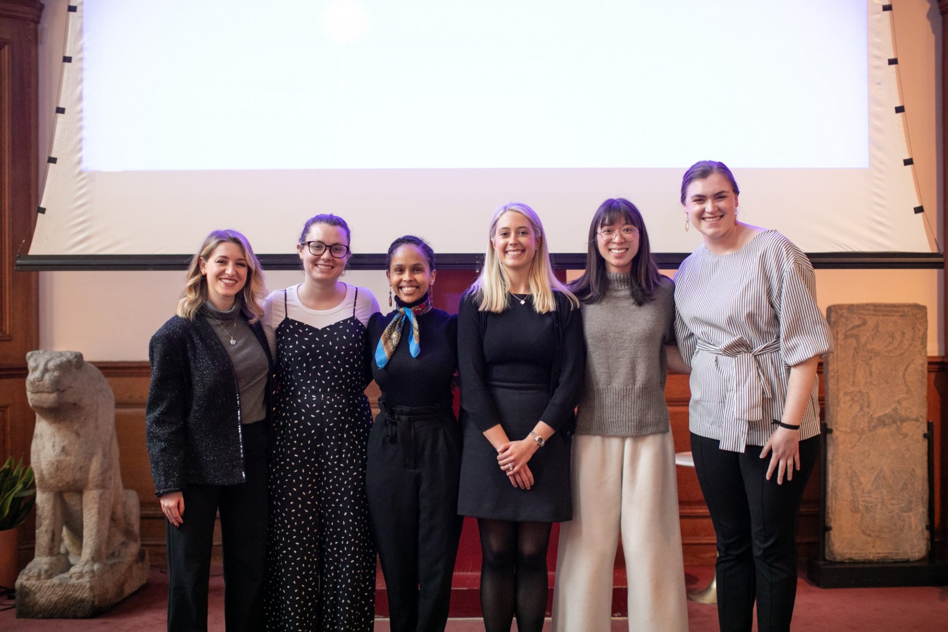 6 people standing in a row, smiling for camera