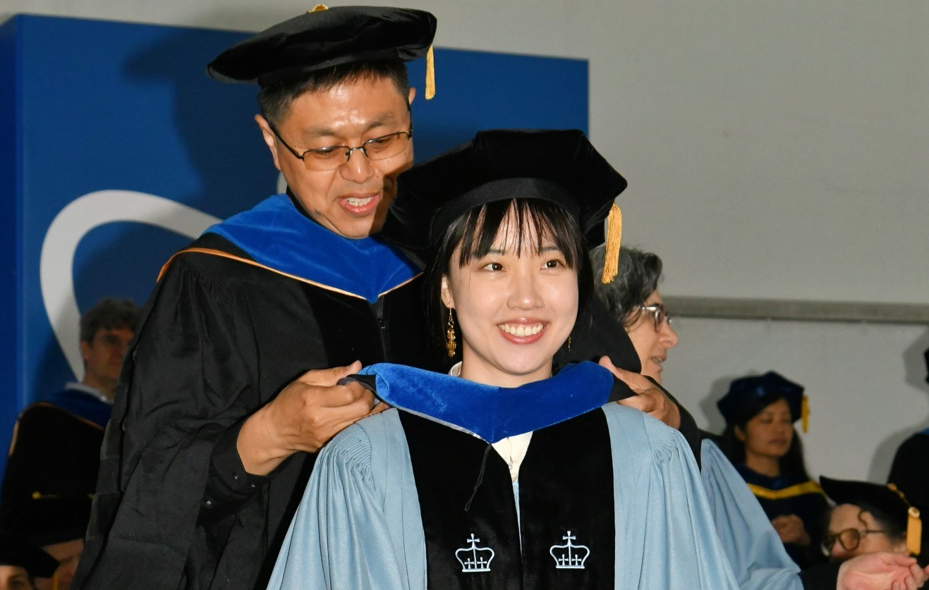 Professor hooding a PhD student in ceremony