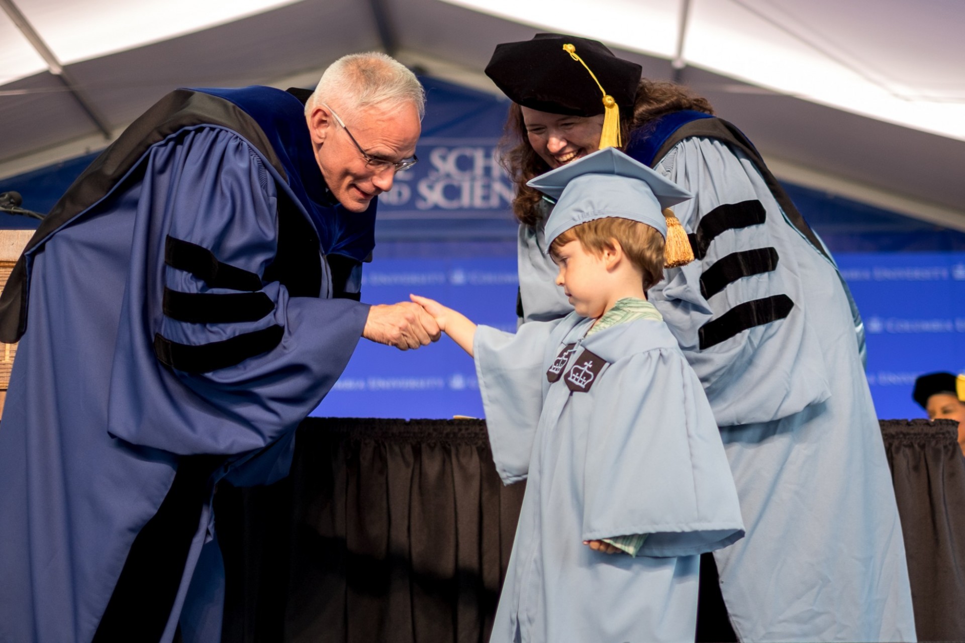 Dean Carlos J. Alonso greets Jennifer Rhodes, PhD candidate in Italian, and her son.