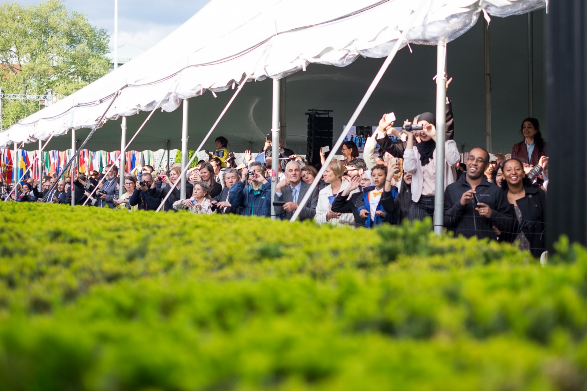 Friends and family look on with excitement as graduates take their seats. Friends and family look on with excitement as graduates take their seats.