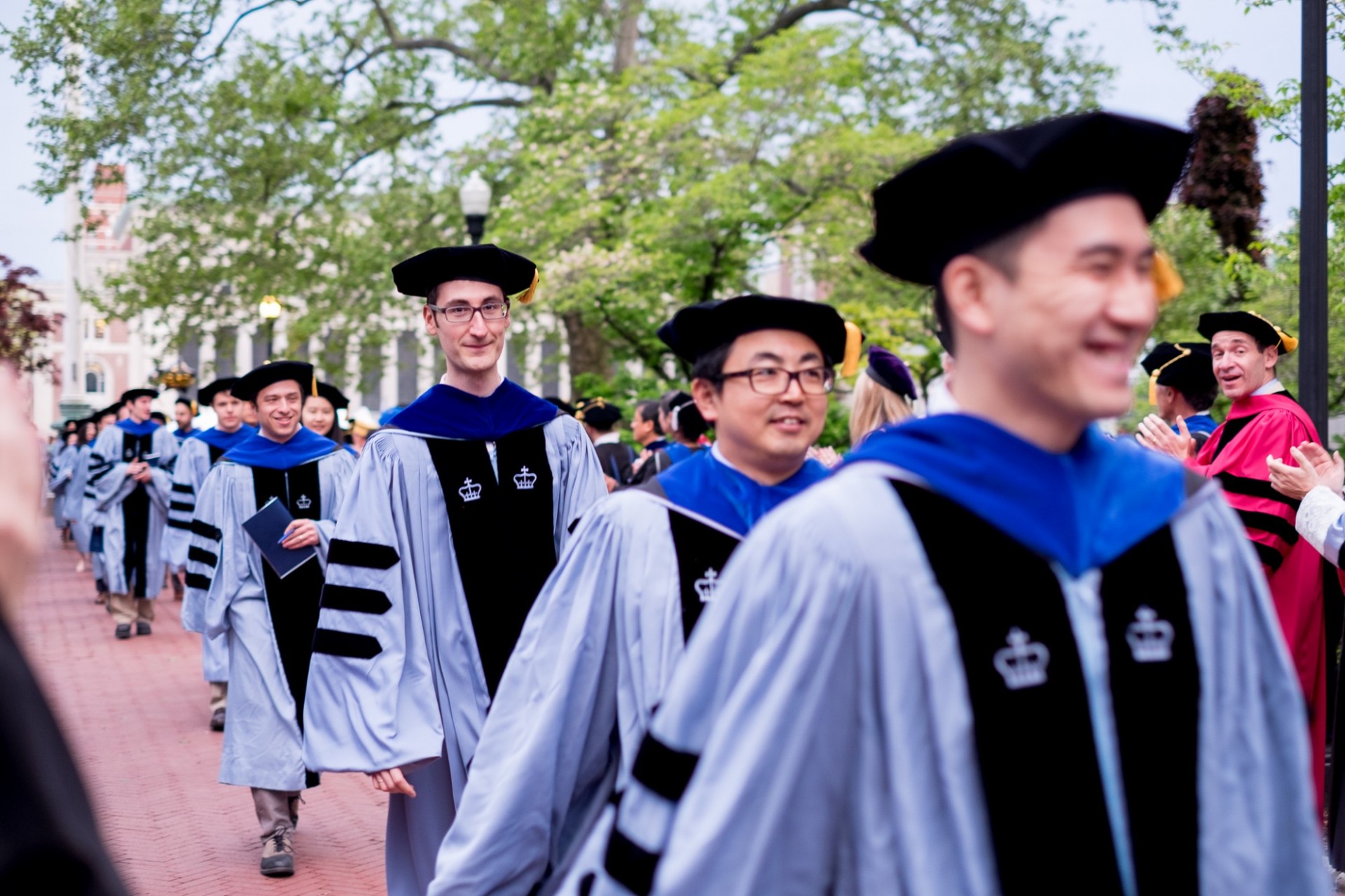 Doctoral graduates are congratulated by faculty as they exit.