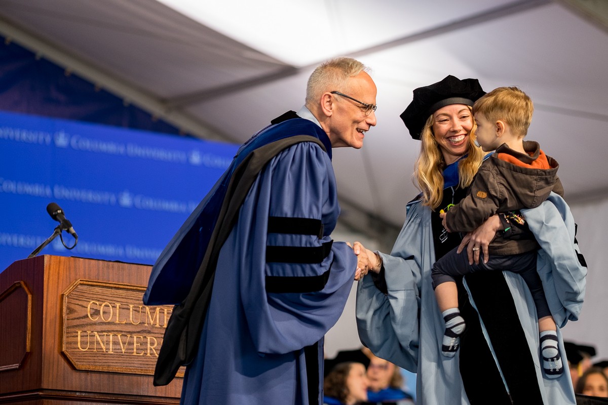 Dean Carlos J. Alonso greets Ashley Greer, PhD candidate in Applied Behavioral Analysis, and her son.