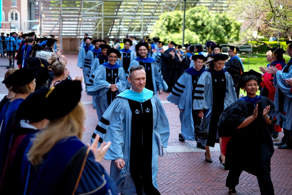 Richard Slusarczyk, EdD, Associate Dean of Academic and Student Affairs, and Celina Chatman Nelson, PhD, Associate Dean for Academic Diversity and Inclusion, lead graduates as they leave the ceremony.