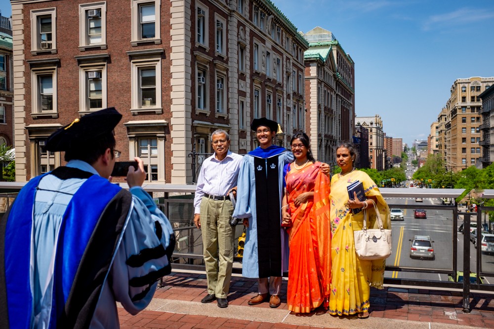 A proud graduate poses for a photo with his family at Ancel Plaza above Amsterdam Avenue. A proud graduate poses for a photo with his family at Ancel Plaza above Amsterdam Avenue.