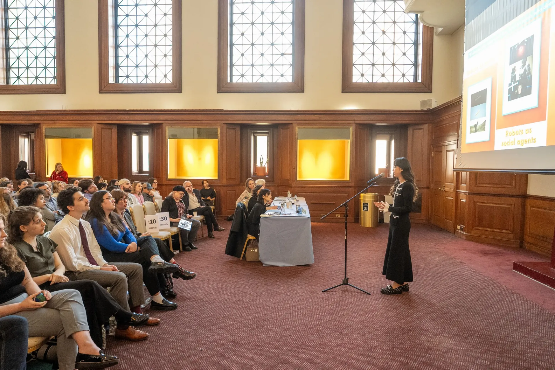 A woman speaking before a large audience.