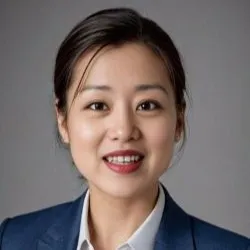 A woman with her brown hair in an updo smiles for a professional photo, she is wearing a blazer.
