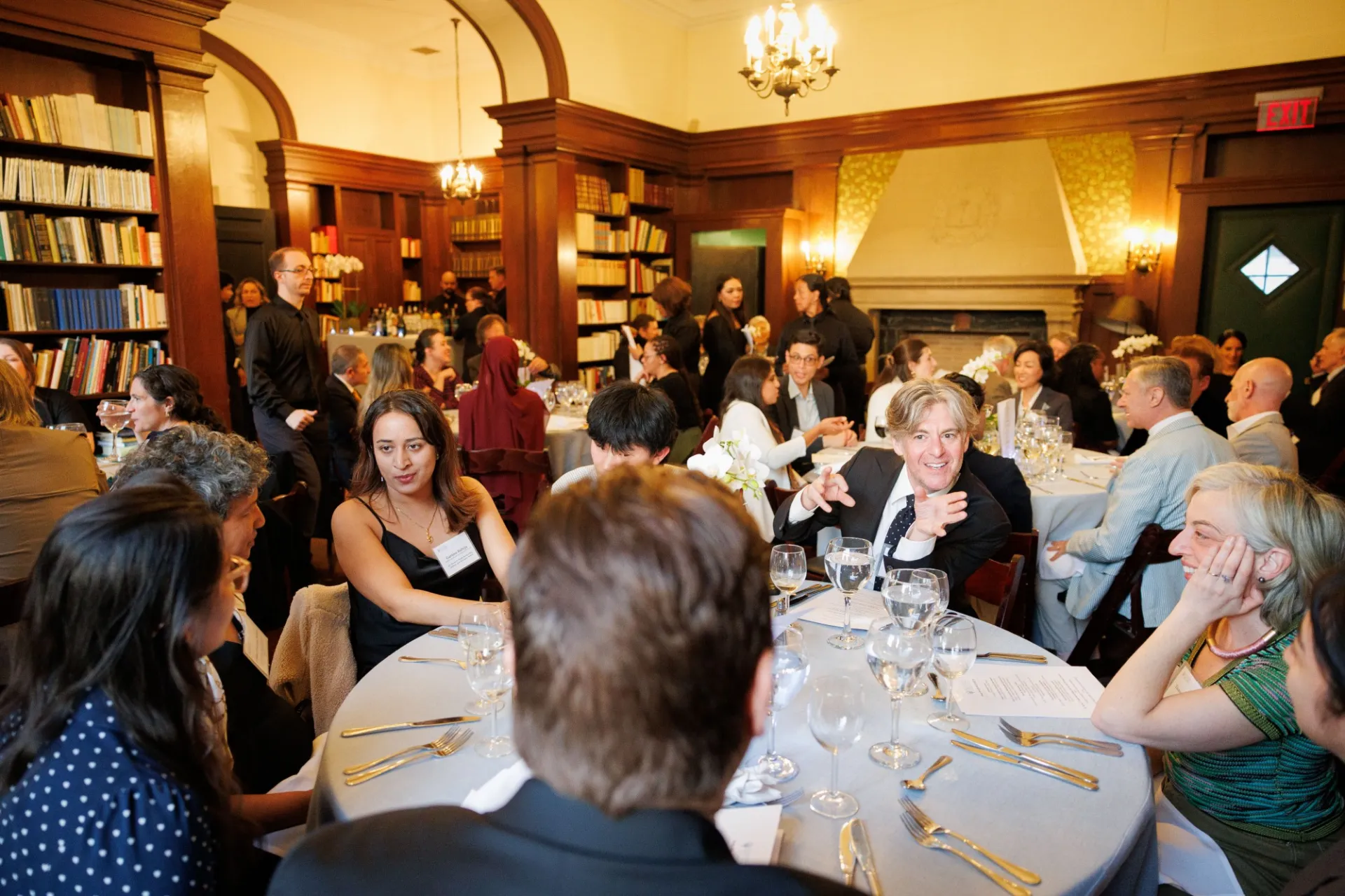 Guests chatting at a dinner table.