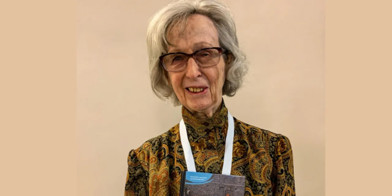 A portrait of a elderly woman with glasses and a gray bob.