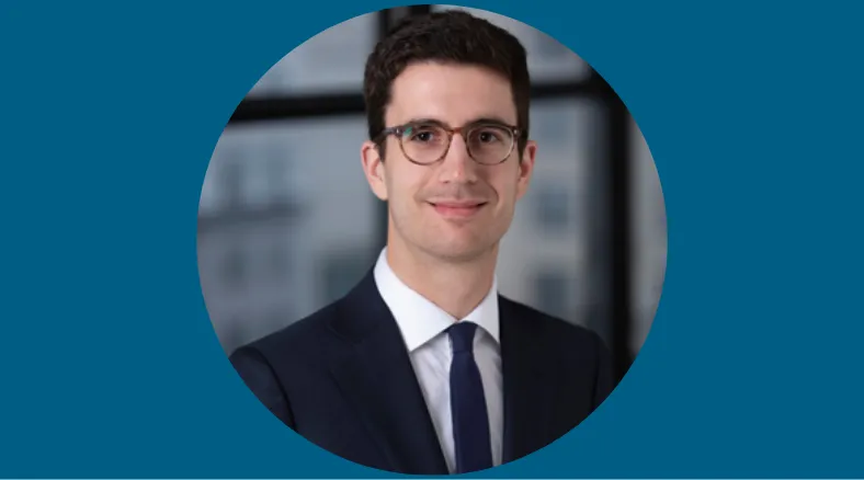 A portrait of a man in a suit with glasses.