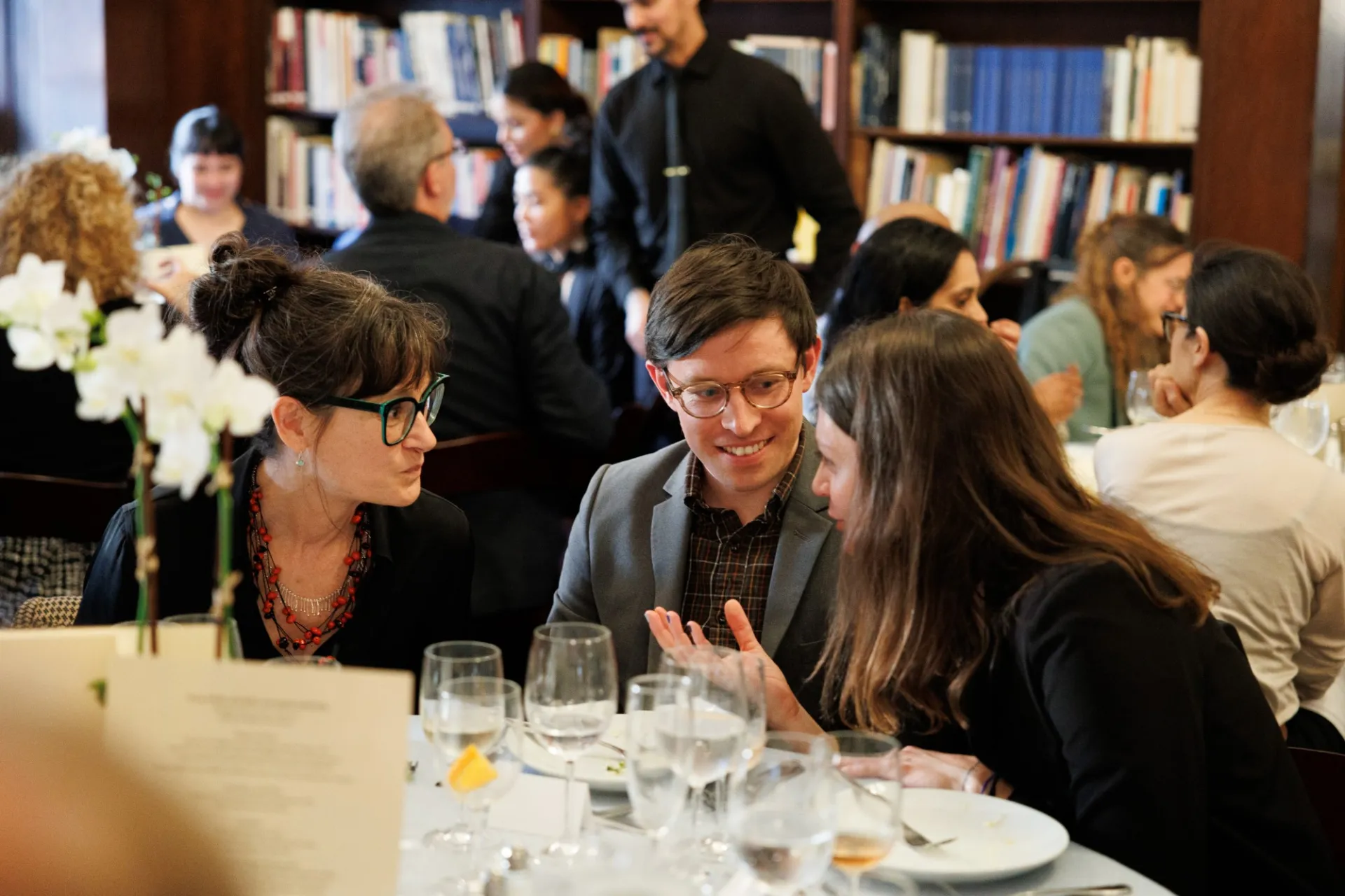 people talking seated at a dinner table 