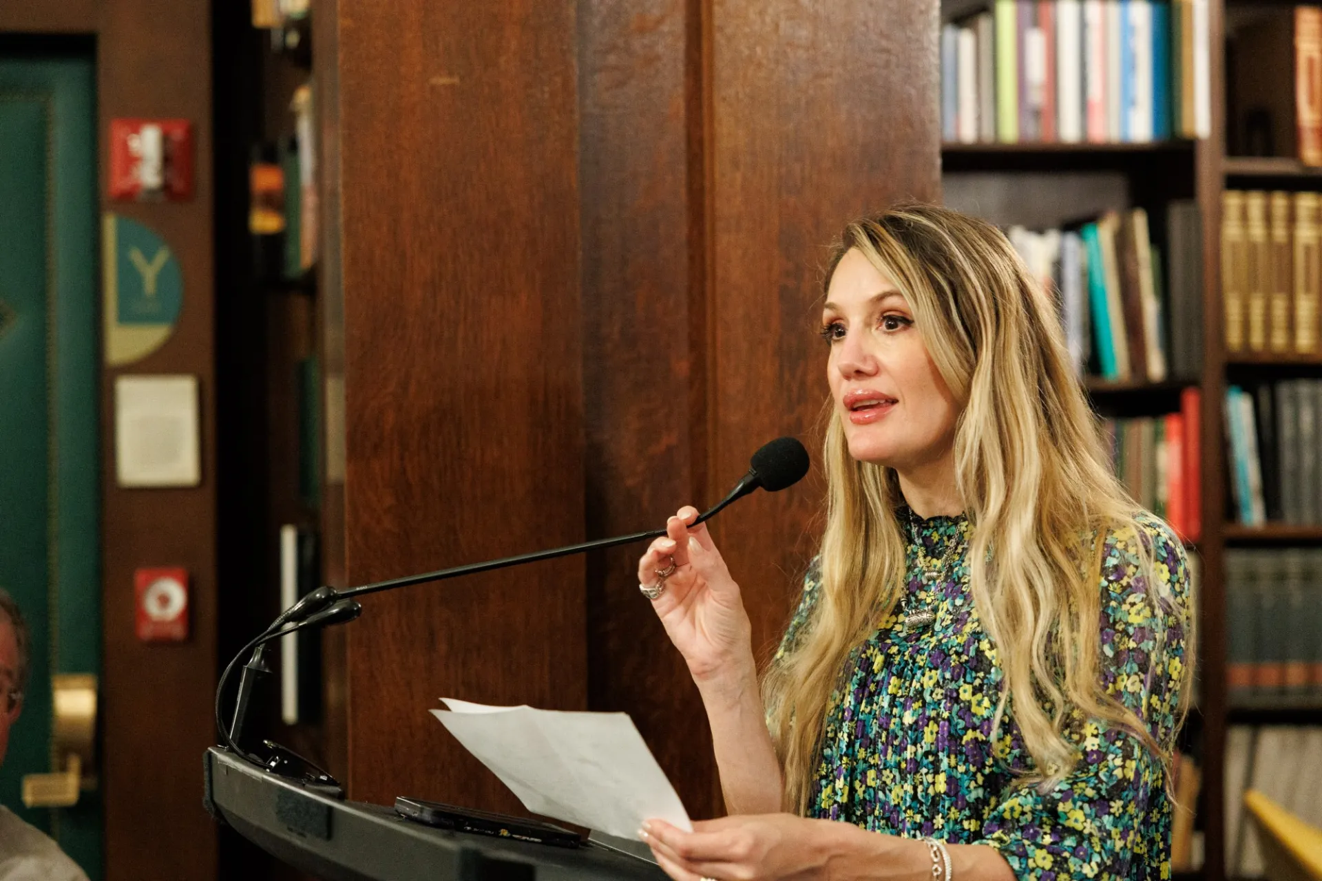 Woman with long hair at lectern speaking