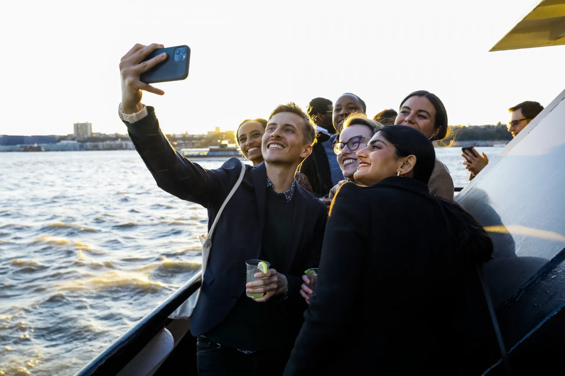 A group of people pose for a selfie on a boat.