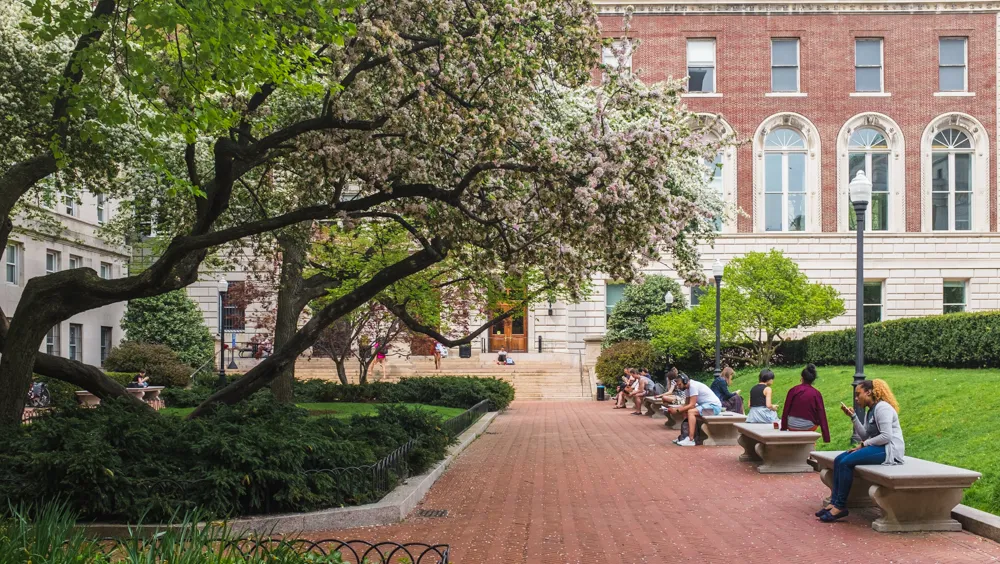 People sitting on benches on the Columbia campus
