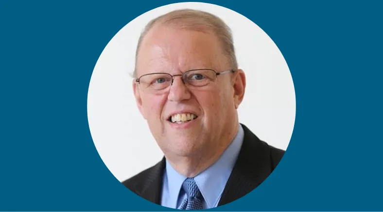 A portrait of a man in a suit wearing glasses.
