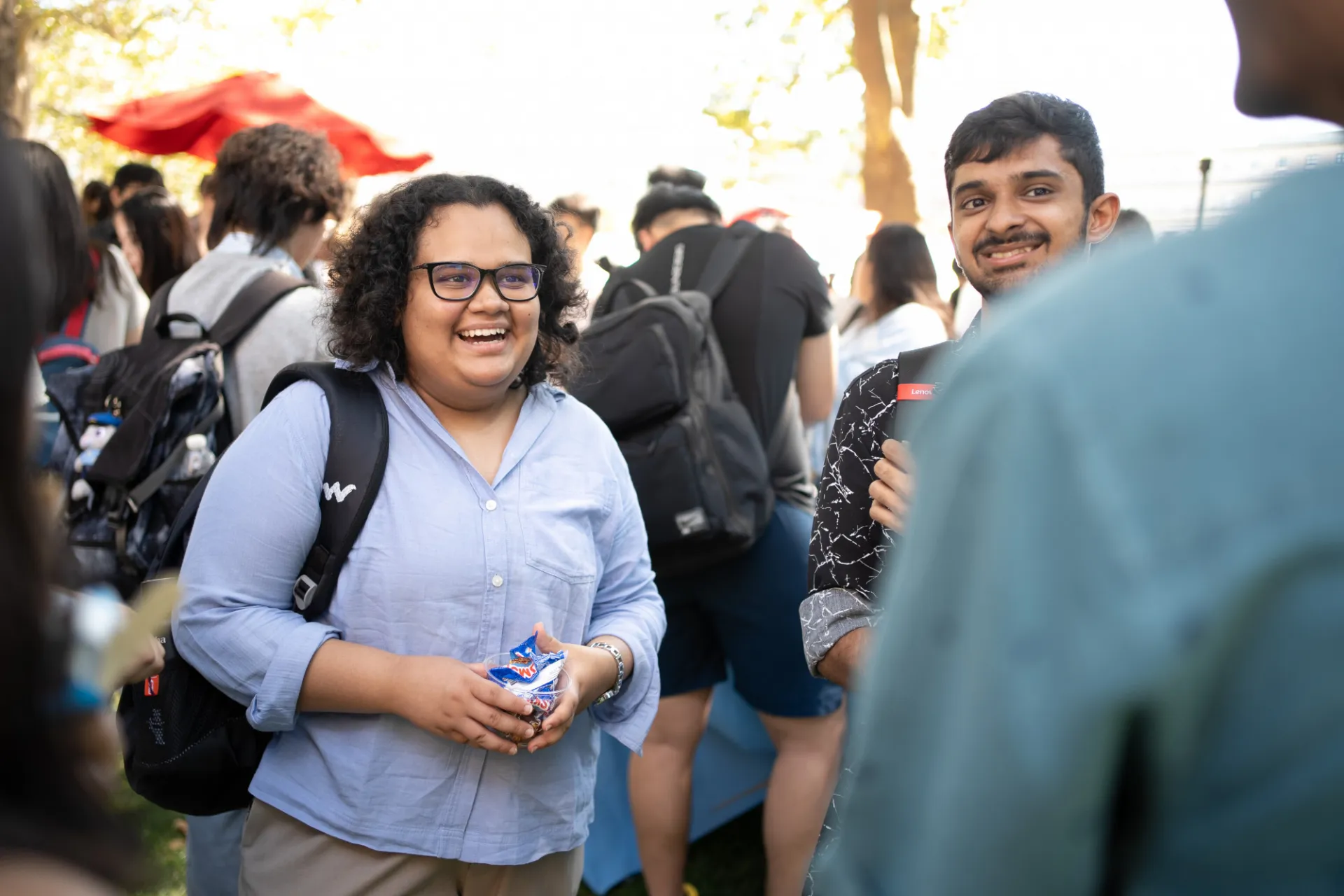 A smiling student talking with a group.