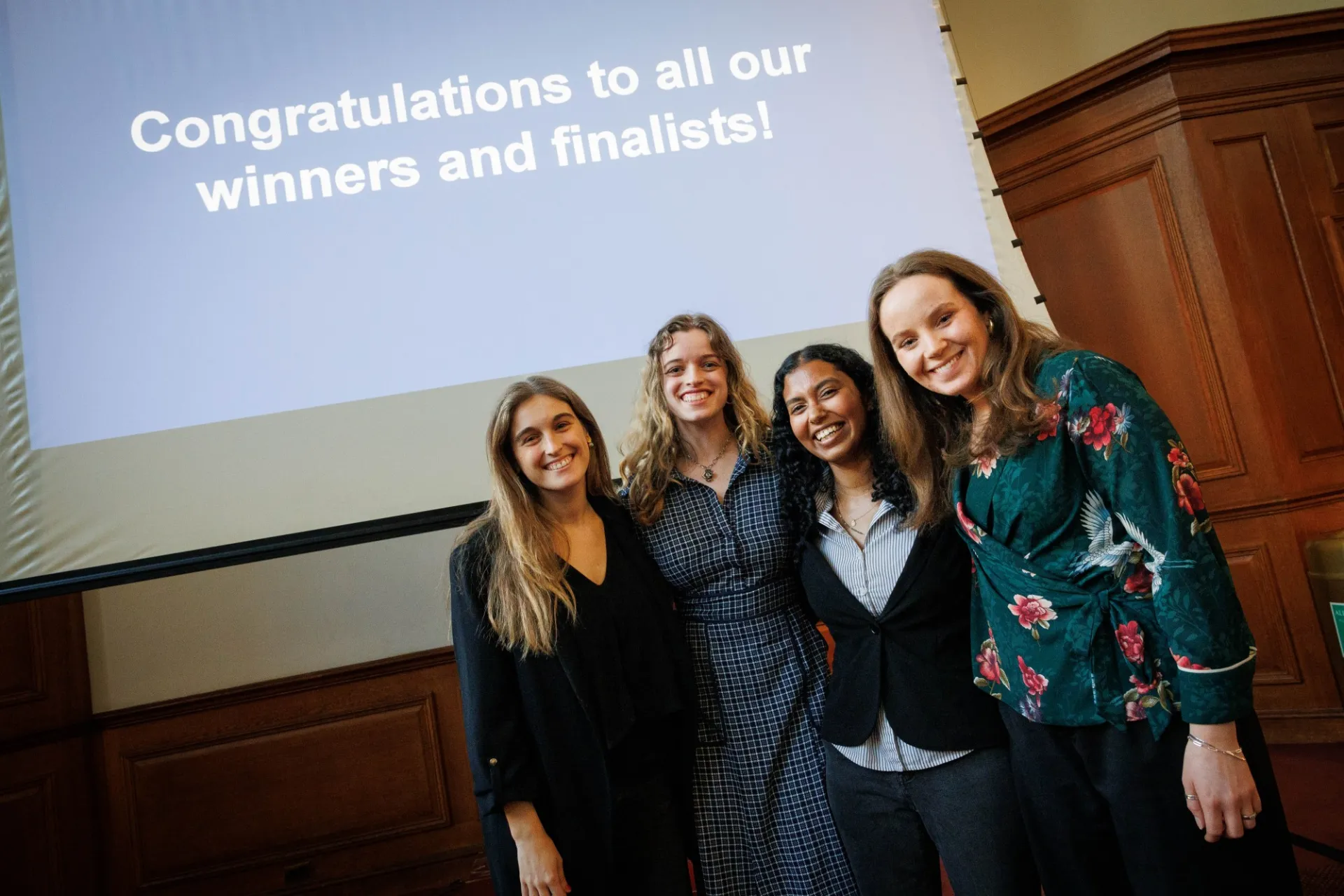 4 women standing together, smiling