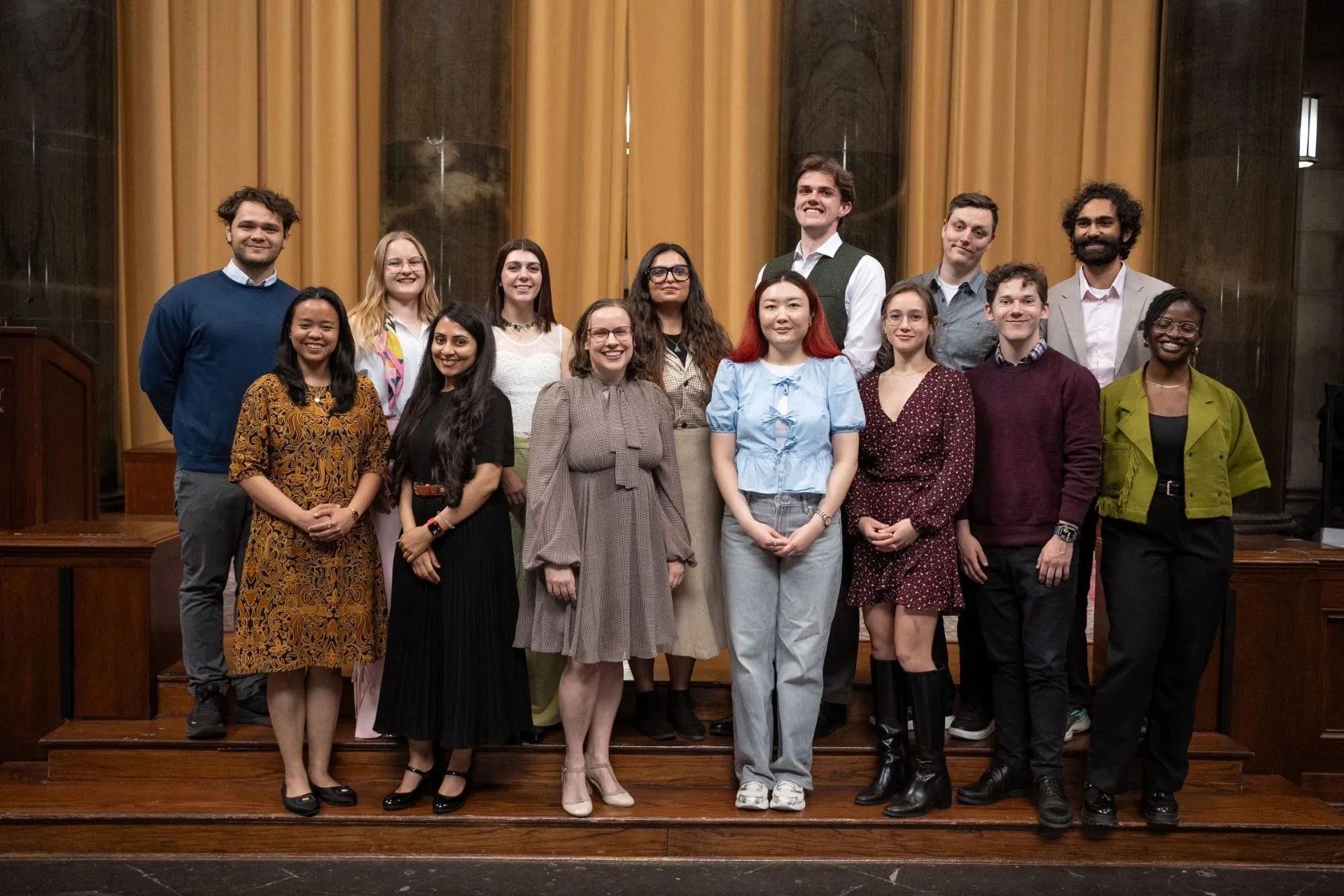 A group shot of students in two rows smiling.