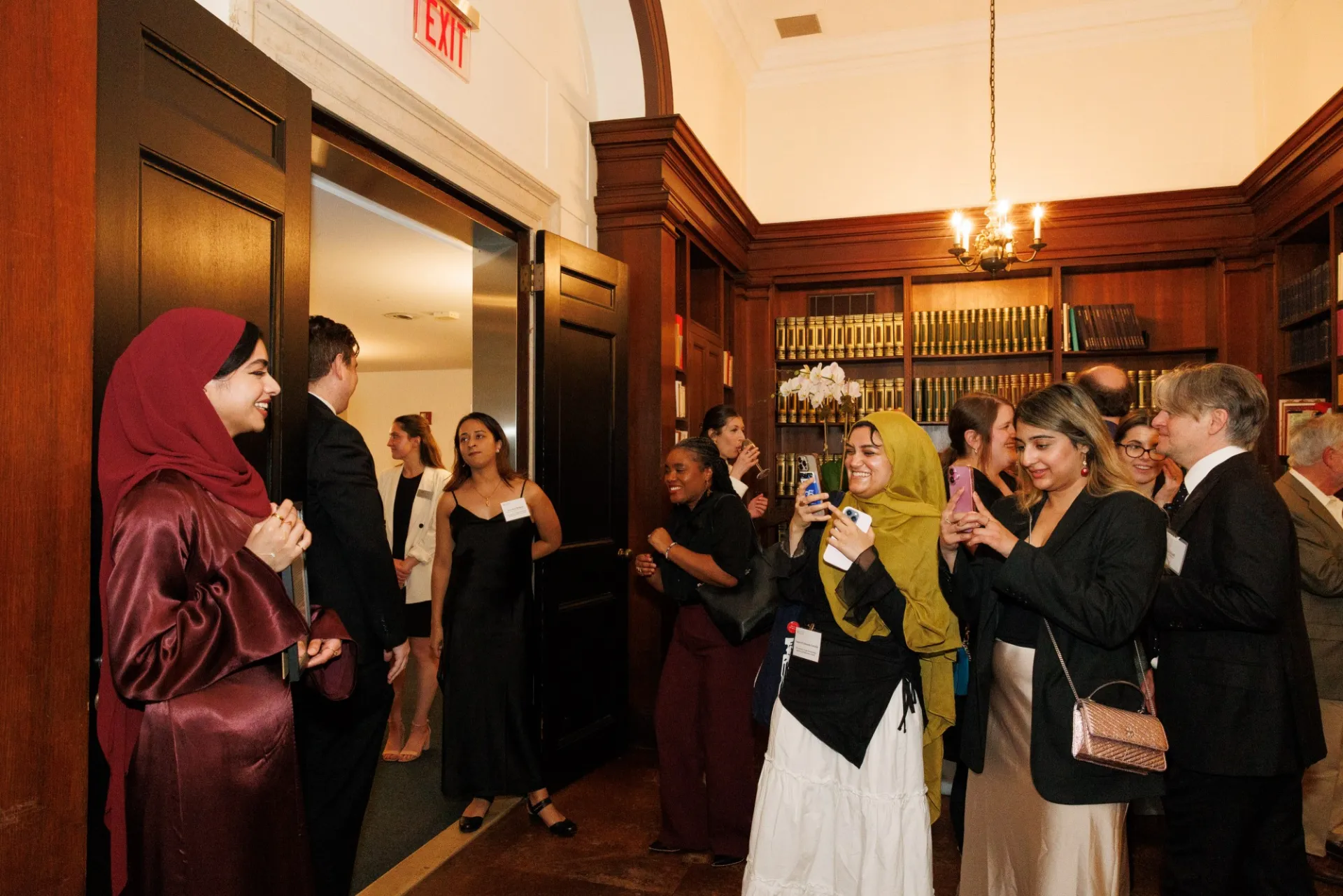A woman poses for a photo taken by two other women.